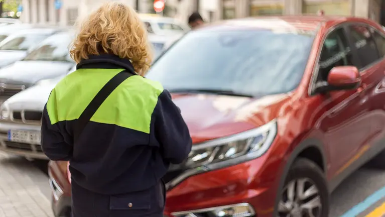 Una vigilante de la zona azul de Pamplona realiza su trabajo en el centro de Pamplona. IÑIGO ALZUGARAY
