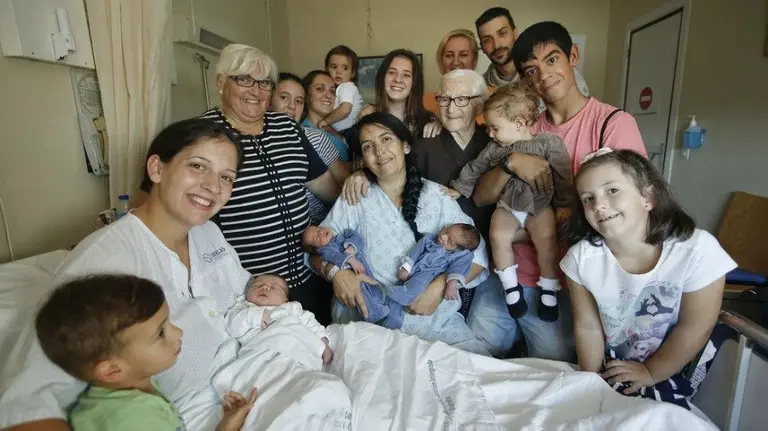 Pili Loureiro y Ruth Lendoiro, junto a sus hijos y otros familiares, en su habitación del hospital en A Coruña. MARCOS MÍNGUEZ