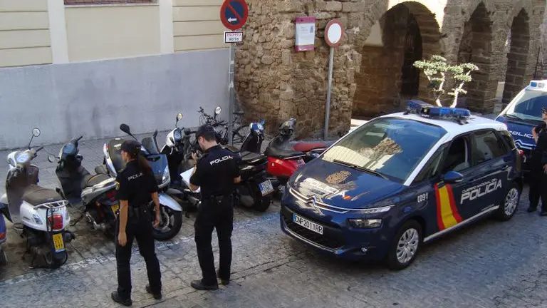 Dos agentes de la Policía Nacional junto a su coche patrulla. EFE/ARCHIVO