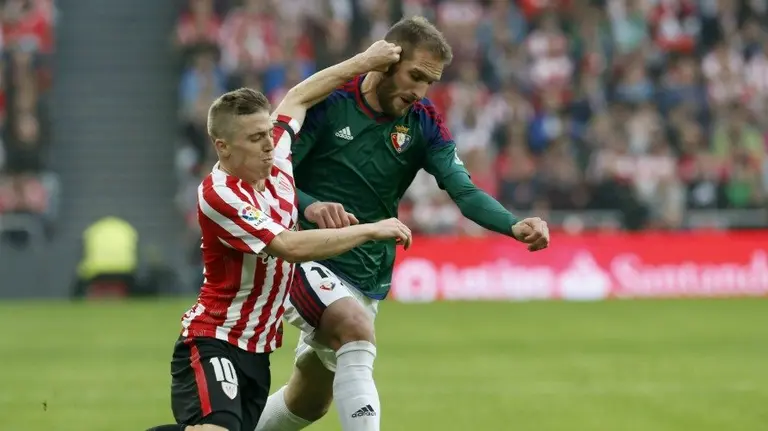 El centrocampista del Athletic Iker Muniain (i) y el centrocampista del Osasuna Fausto Tienza, durante el partido en San Mamés. EFE/LUIS TEJIDO
