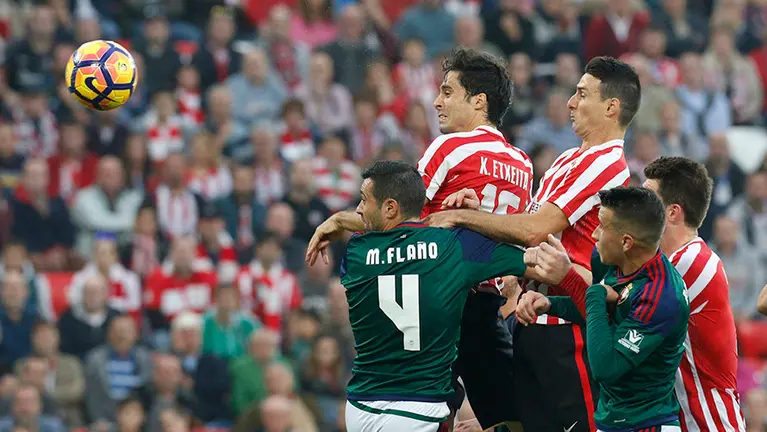 GRA195. BILBAO, 30/10/2016.- Los jugadores del Athletic de Bilbao Xabier Etxeita (c) y Aritz Aduriz (d) cabezean un balón ante el defensa de Osasuna Miguel Flaño (i), durante el partido de la décima jornada de Liga que disputan en el estadio San Mamés de Bilbao. EFE/LUIS TEJIDO