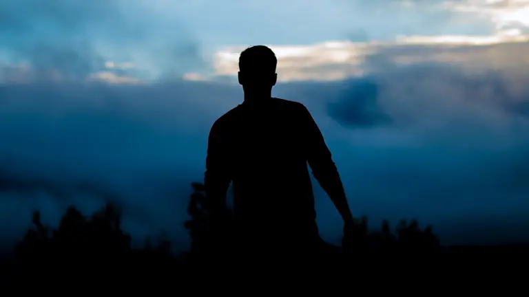 Una persona se dirige por un camino con una maleta. ALAN LABISCH