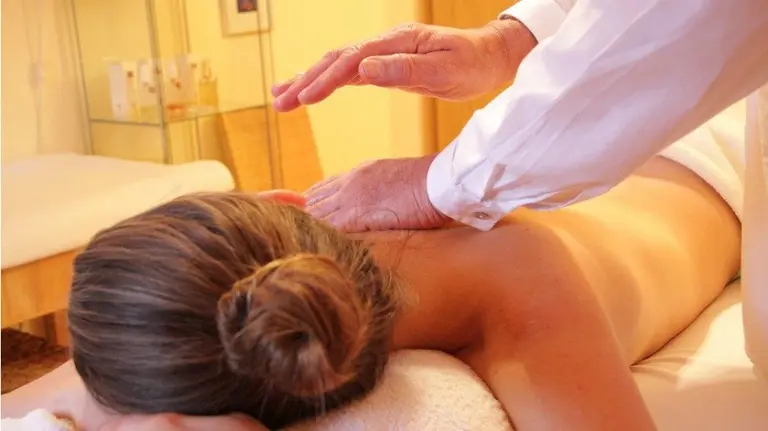 Un profesional da un masaje a una paciente.