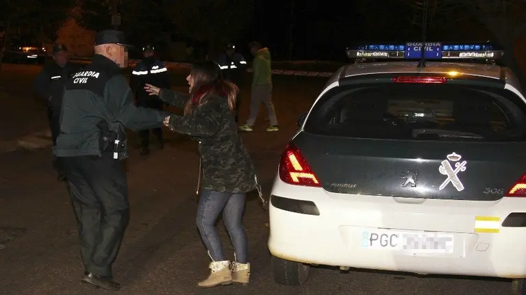 Un guardia civil habla con una mujer cerca de la vienda donde han sido hallados los cadáveres J. Casares Efe