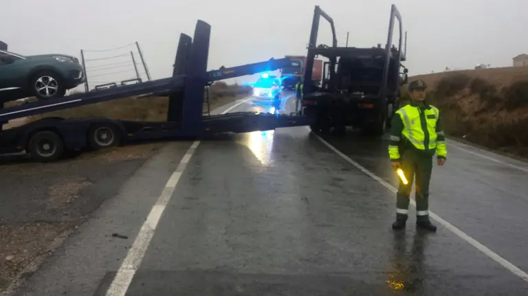Un agente de la Guardia Civil controla el tráfico en la NA-135 en Tudela con el camión cruzado