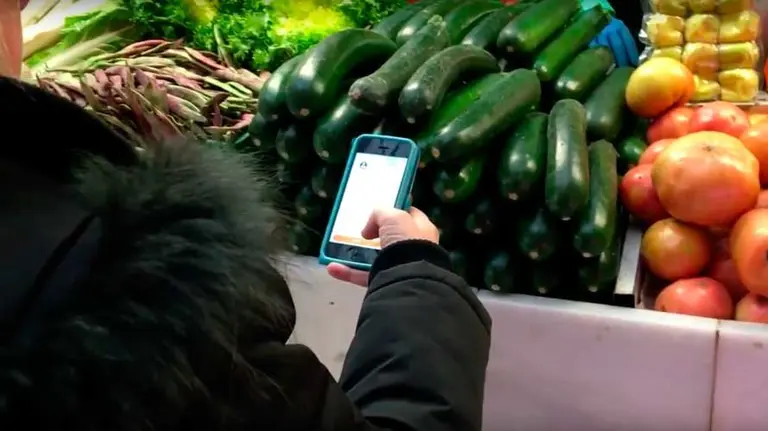 Una clienta paga su compra con el móvil en el Mercado de Santo Domigo de Pamplona. BOLETUS