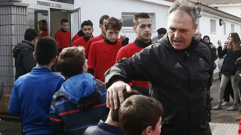El entrenador de Osasuna Joaquín Caparros saluda a un joven aficionado, durante el entrenamiento este jueves festivo, Día de la Inmaculada, en las instalaciones de Tajonar previo al partido de Liga que el equipo disputa este sábado en el Estadio de El Sadar ante el F.C Barcelona. EFE/Jesús Diges