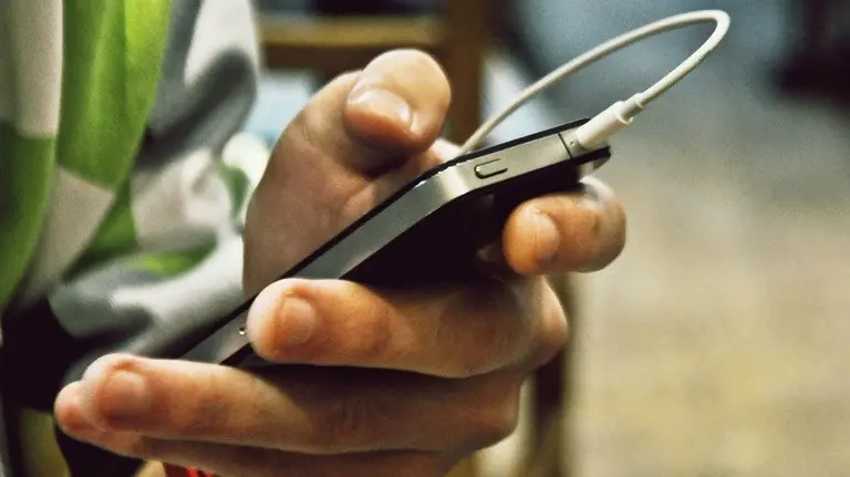 Un joven escucha música en un iPhone. APPLE