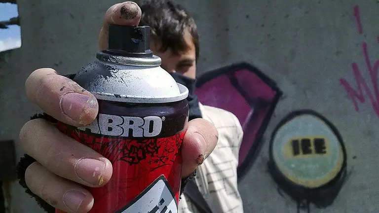 Imagen de archivo de un joven grafitero mostrando el bote de spray empleando para realizar las pintadas ARCHIVO
