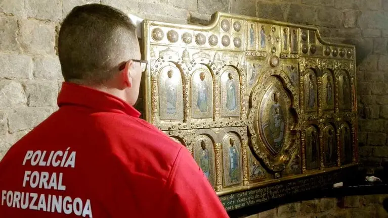 Agente de la Policía Foral durante el momento en el qu ese ha bajado el retablo de San Miguel de Aralar. PFORAL
