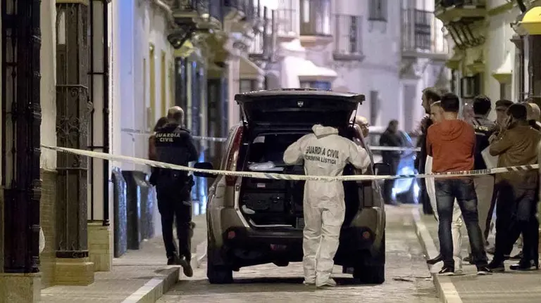 Agentes de Criminalística de la Guardia Civil en la puerta de la vivienda. EFE