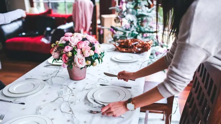 Varias personas preparan la mesa para cenar esta Nochebuena