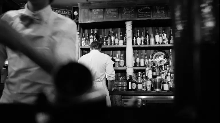 Dos camareros trabajan en un bar. ARCHIVO