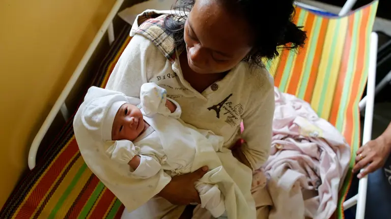 Una mujer sostiene a su bebé recién nacido en una escuela habilitada como refugio tras el paso del tifón Nock-Ten por la localidad de Pamplona, Camarines Sur (Filipinas), el 26 de diciembre de 2016; al menos tres personas han muerto. EFE/Francis R. Malasig