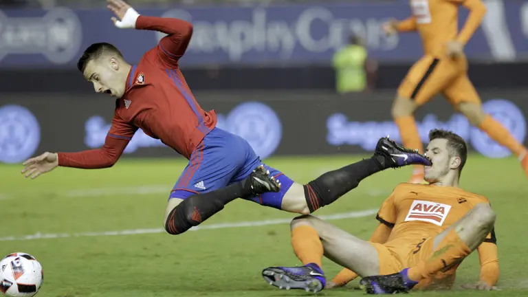 El jugador de Osasuna Alejandro Berenguer (i) lucha por un balón ante el jugador del Eibar Cristian Rivera (d), durante el partido de ida de los octavos de final de la Copa del Rey disputado esta noche entre el equipo navarro y el conjunto vasco en el estadio El Sadar. EFE/Villar López