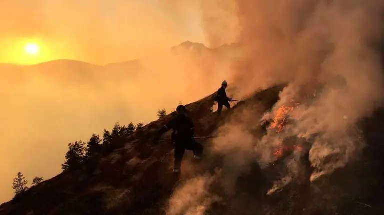 Efectivos de los bomberos realizando labores de extinción a mano en el monte Lakora.