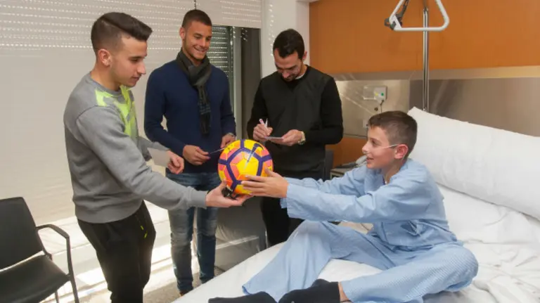 Los jugadores rojillos entregan regalos a los niños del CHN.