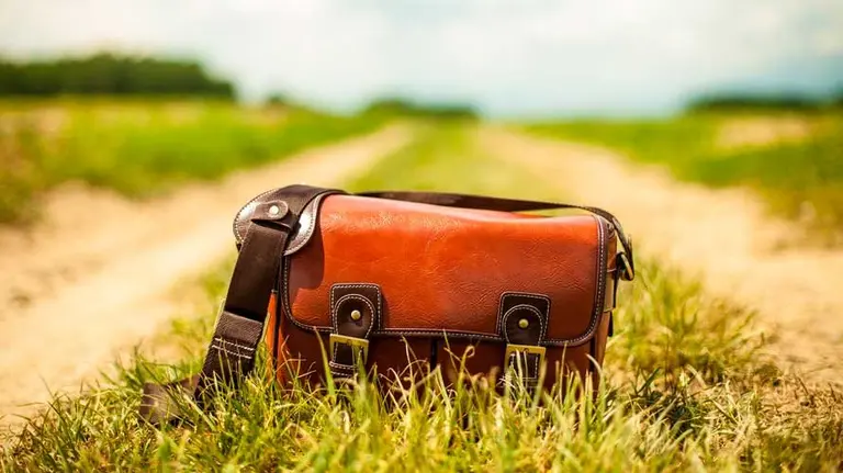 Bolso tirado en un camino.