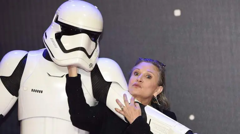 R. UNIDO CINE STAR WARS:FA0025- LONDRES (REINO UNIDO), 16/12/2015.- La actriz estadounidense del reparto Carrie Fisher posa junto a uno de los personajes Stormtrooper en la alfombra roja hoy, miércoles 16 de diciembre de 2015, en el prestreno de la película "Star Wars: El despertar de la Fuerza", en Leicester square en Londres, Reino Unido. Se estrena el séptimo episodio de la saga con la que George Lucas revolucionó el negocio del cine hace casi cuatro décadas. EFE/FACUNDO ARRIZABALAGA


