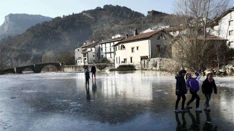 Tiempo. Un grupo de jóvenes juegan al balón sobre la superficie helada del Río Esca a su paso por la localidad navarra de Burgui. EFE.  Jesús Diges