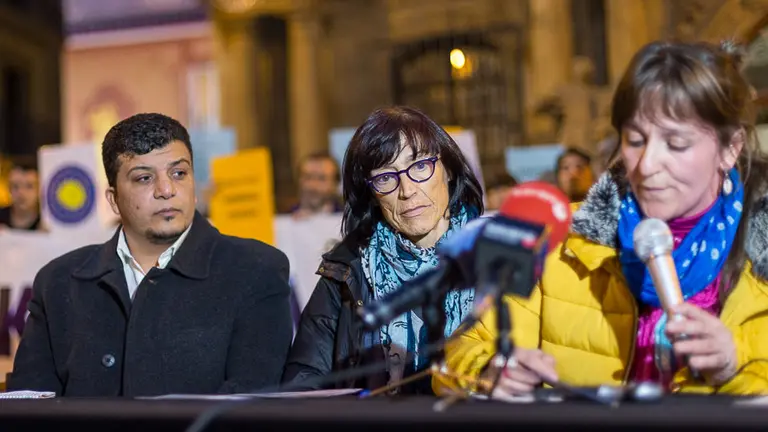 La vecina de Pamplona Begoña Huarte recién llegada a Navarra tras su detención en Grecia, junto con voluntarios de la asociación Help-Na, el refugiado sirio Abdu Razak Yoseef y miembros de Iruñea Ciudad de Acogida, ofrece una rueda de prensa en la plaza del Ayuntamiento. IÑIGO ALZUGARAY
