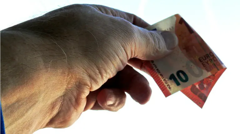 Un hombre paga con un billete de 10 euros. ARCHIVO