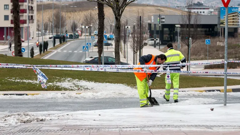 Operarios del Ayuntamiento trabajan para limpiar la vía y arreglar la fuga que ha producido una gran placa de hielo en el cruce entre la Avda. Juan Pablo II y la calle Cataluña. IÑIGO ALZUGARAY