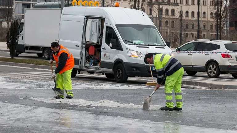 Operarios del Ayuntamiento trabajan para limpiar la vía y arreglar la fuga que ha producido una gran placa de hielo en el cruce entre la Avda. Juan Pablo II y la calle Cataluña. IÑIGO ALZUGARAY