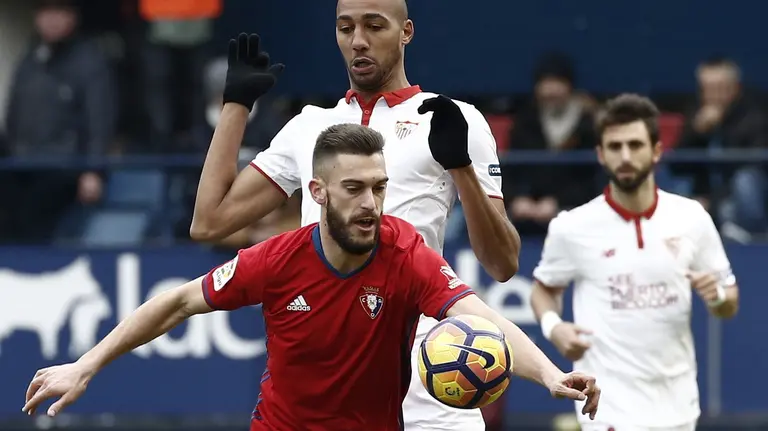 El centrocampista del Osasuna Roberto Torres con el balón ante el centrocampista francés del Sevilla Steven N'Zonzi, durante el partido de la jornada 19 de liga de Primera División disputado hoy en el estadio de El Sadar. EFE/Jesús Diges