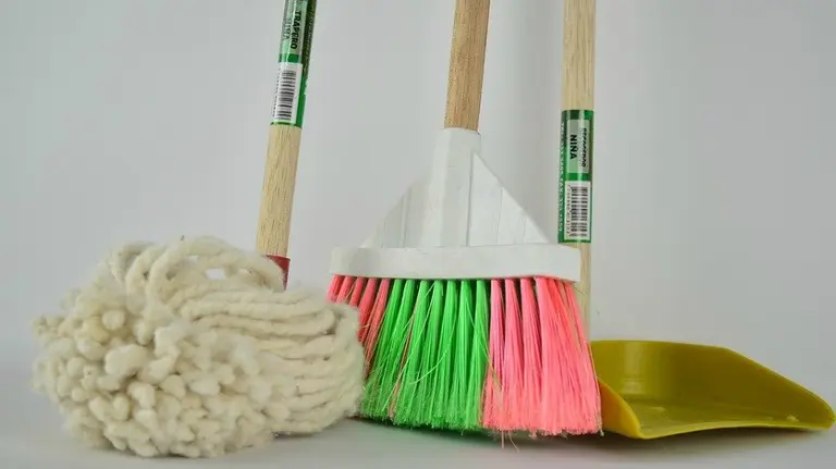 Una escoba, una fregona y un escobón. Útiles de limpieza.