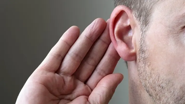 Un hombre se lleva la mano a la oreja para intentar escuchar algo que le dicen ARCHIVO
