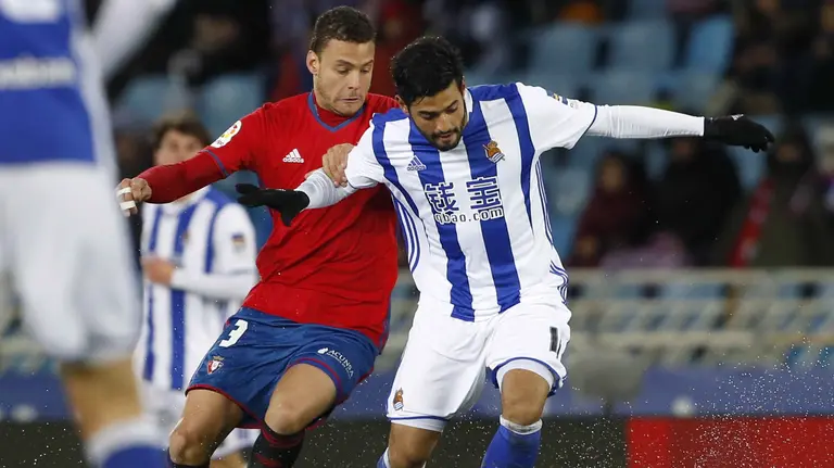 El delantero mexicano de la Real Sociedad Carlos Alberto Vela (d) y el defensa del Osasuna Cayetano Bonnín durante el encuentro de la jornada 21 de Liga en Primera División que se ha jugado esta tarde en el estadio de Anoeta, en San Sebastián. EFE/Javier Etxezarreta.