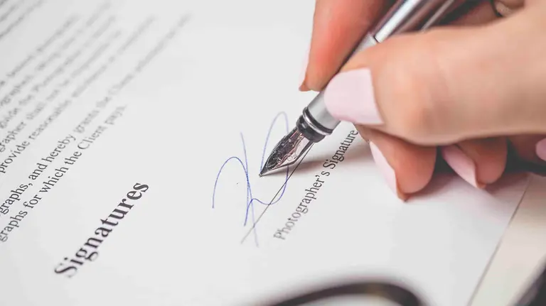 Mujer firmando un contrato. ARCHIVO