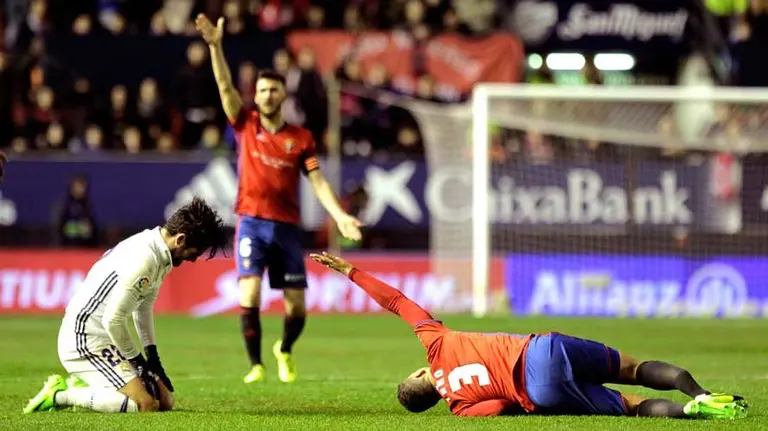 El jugador de Osasuna Tano (d) se lesiona ante Isco (i), del Real Madrid, durante el partido de Liga en Primera División disputado esta noche en el estadio de El Sadar. EFE