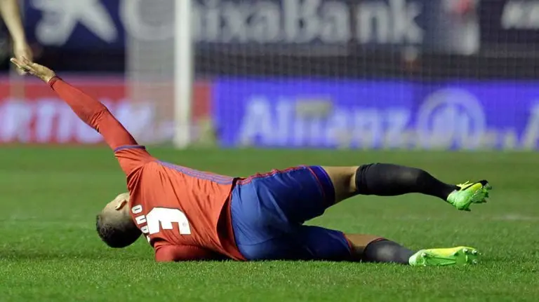 El jugador de Osasuna Tano (d) se lesiona ante Isco (i), del Real Madrid, durante el partido de Liga en Primera División disputado esta noche en el estadio de El Sadar. EFE