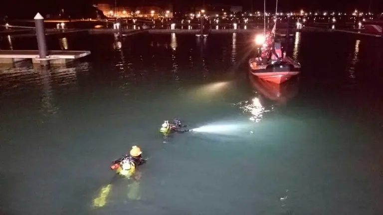 Los buzos acceden al vehículo sumergido a 6 metros de profundidad en el Puerto deportivo de Laredo. EP