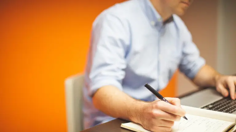 Un hombre trabajando en una oficina frente a un ordenador