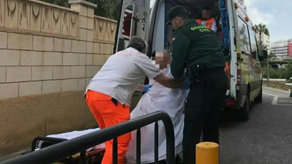 Los servicios médicos y la Guardia Civil trasladan el cuerpo de la mujer asesinada en una residencia de El Campello GC