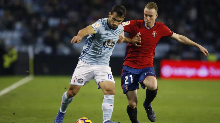 El defensa del Celta de Vigo, Jonathan Castro "Jony" (I), protege el balón ante el acoso del jugador de Osasuna, Carlos Clerc, durante el encuentro correspondiente a la jornada 23 de primera división, que han disputado esta noche en el estadio de Balaídos, en Vigo. EFE/Salvador Sas.
