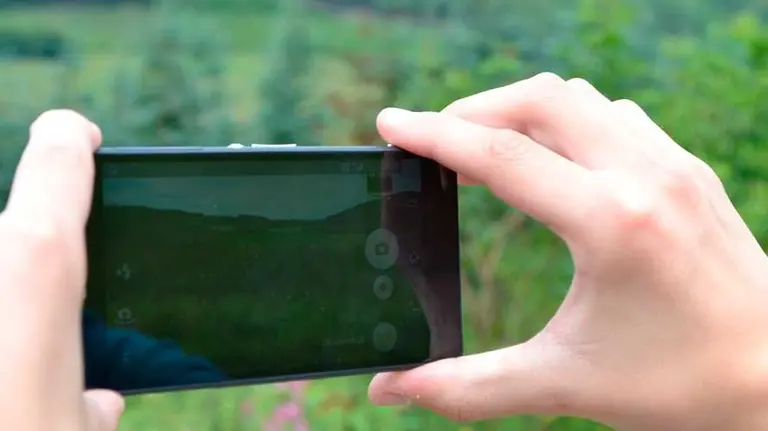 Una persona saca una foto del paisaje con su teléfono móvil. ARCHIVO