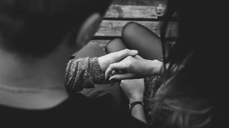 Imagen de un pareja de novios tomándose de la mano sentados en el banco de un parque ARCHIVO