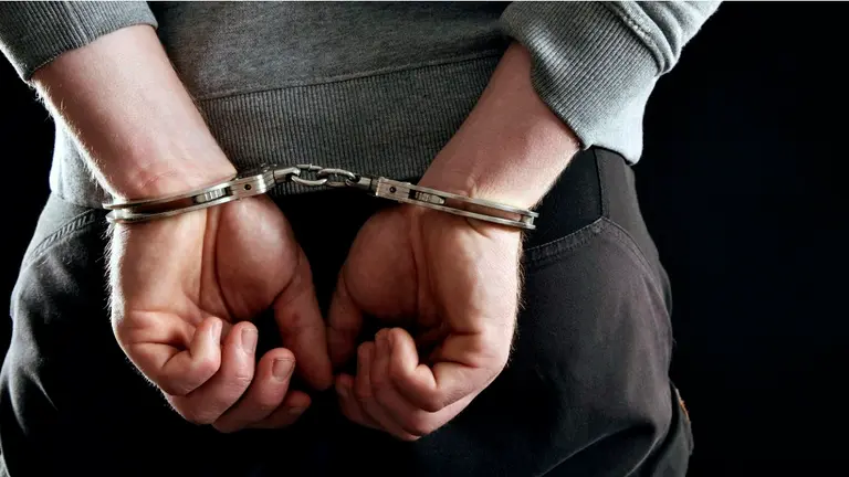 Un hombre detenido y esposado es conducido por la policía. ARCHIVO 