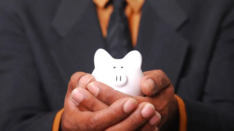 Un hombre sostiene una hucha solidaria ARCHIVO