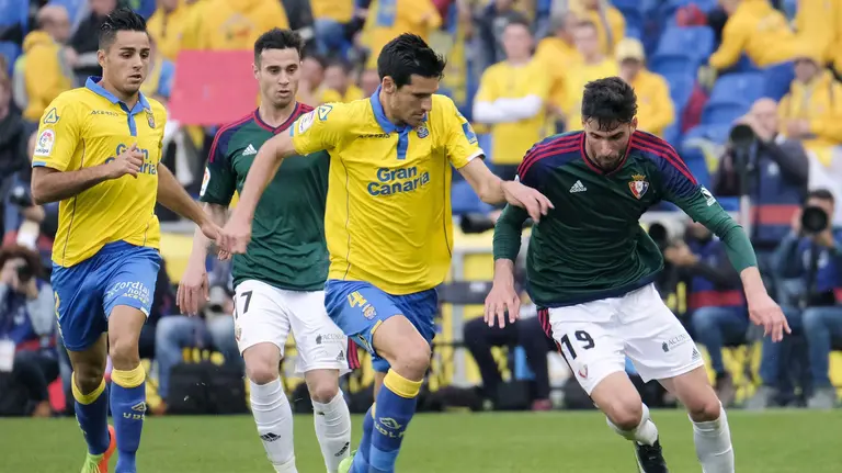 El centrocampista de la UD Las Palmas Vicente Gómez (2-d) defiende la internada de Kenan Kodro (d), de Osasuna, durante el partido de Liga en Primera División disputado esta tarde en el estadio de Gran Canaria, de Las Palmas. EFE/Ángel Medina