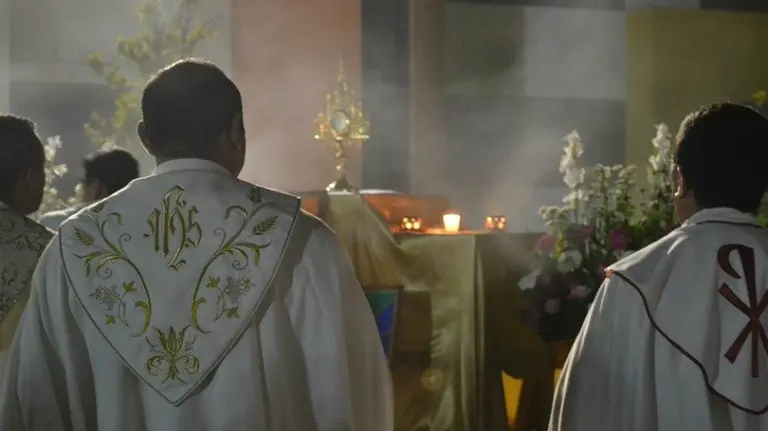 Tres curas de espaldas en una iglesia. ARCHIVO
