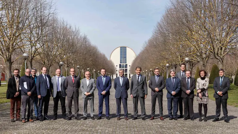 La delegación de Volkswagen Navarra y miembros de la UPNA posan en el campus de Arrosadia, con la biblioteca al fondo