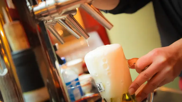 Un camarero tira una cerveza de barril ARCHIVO