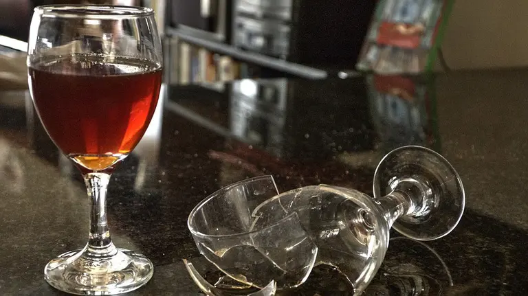 Una copa rota en la barra de un bar.