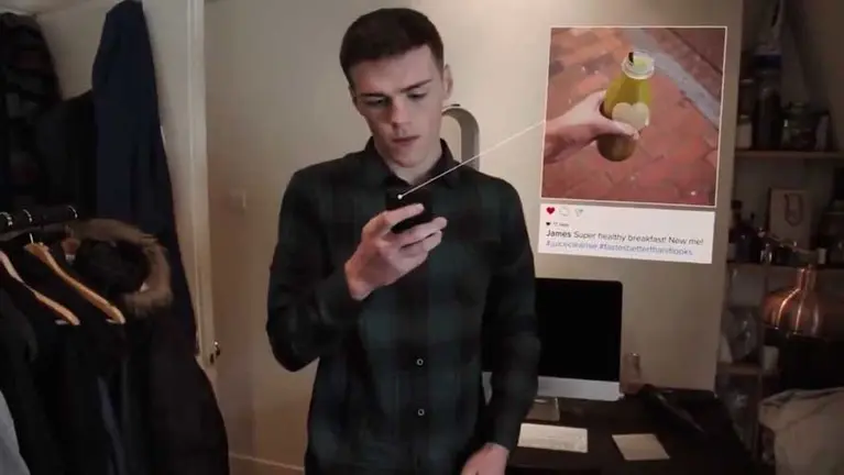 Joven observando su móvil. FACEBOOK