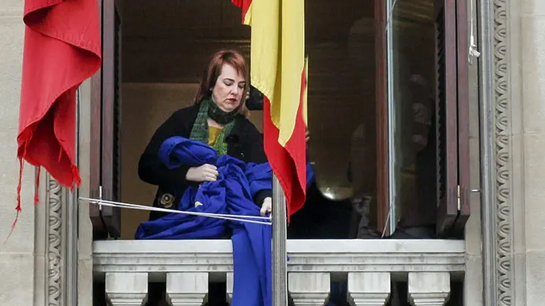 GRA142. PAMPLONA, 18/03/2016.- Fotografía facilitada por el Parlamento de Navarra del momento en el que la la presidenta de la Cámara foral, Ainhoa Aznárez, ha retirado la bandera de la Unión Europea de su lugar oficial en la sede de las cortes regionales, "en tanto y cuanto no haya un expreso rechazo por parte de la Unión a la propuesta realizada por el estado turco" en relación con las personas refugiadas, en cumplimiento del acuerdo adoptado por la Mesa de Portavoces, en una sesión convocada con carácter de urgencia. EFE/